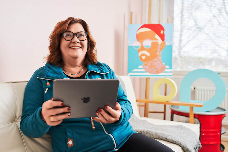 Asiakas käyttää tablettia kotonaan.