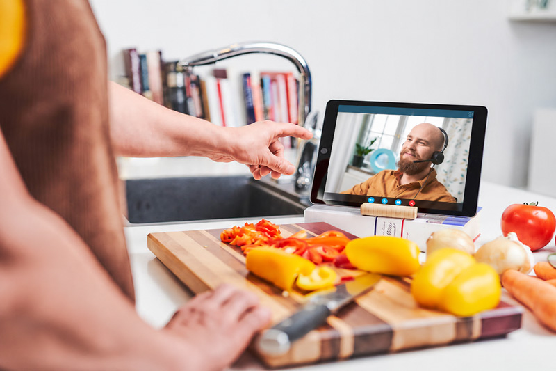 Asiakas keskustelee Kaiku24:n digihoitajan kanssa tabletin videoyhteydellä keittiössään.
